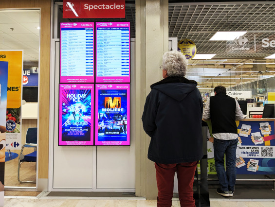Des écrans d'affichage dynamique billetterie chez Carrefour