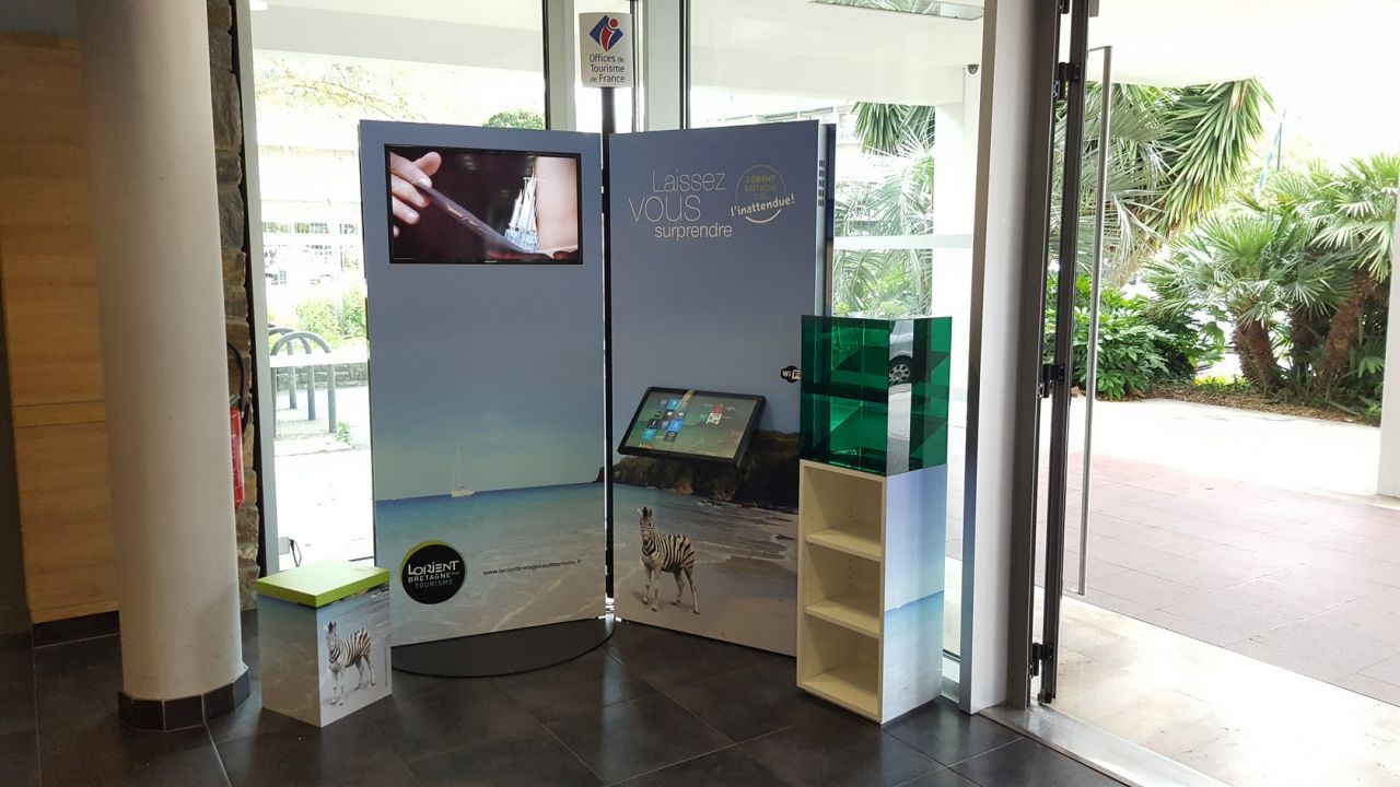 Le point d'information mobile ressemble à un livre ouvert avec écran d'affichage dynamique et tablette interactive