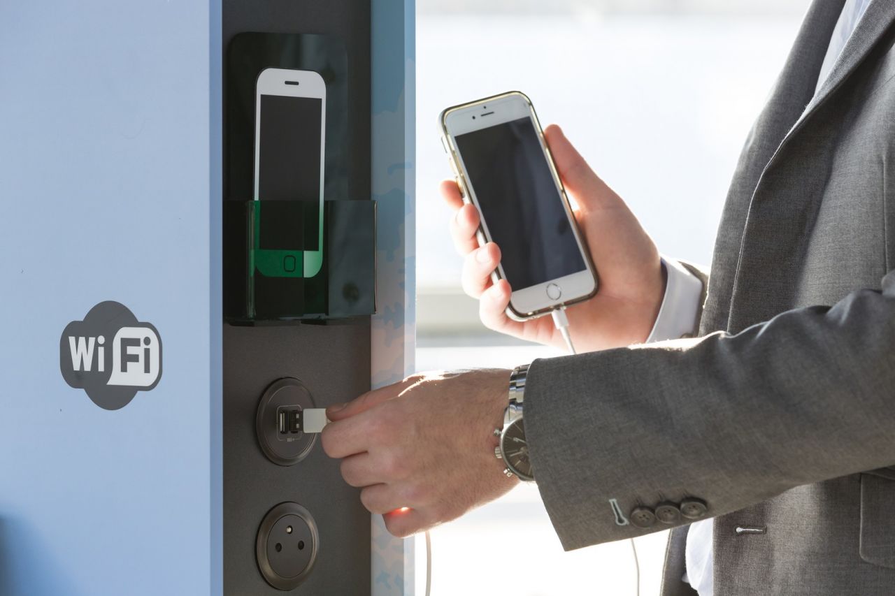 Un visiteur recharge son téléphone mobile sur un point d'information mobile (PIM)
